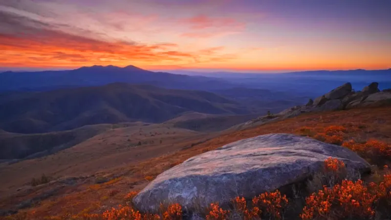 Una figura contempla el inmenso atardecer rocoso