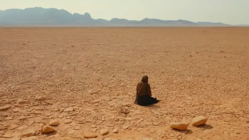 Figura arrodillada en el desierto desolado