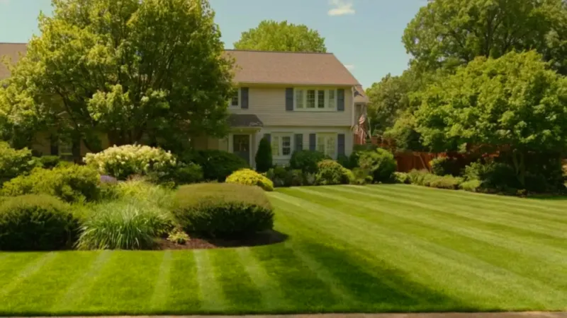 Un hombre corta el césped del jardín