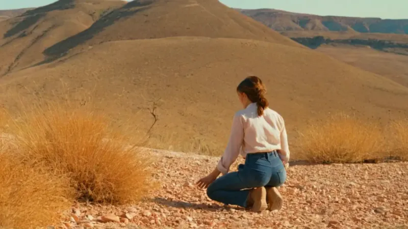 Mujer recolecta plantas en la ladera árida