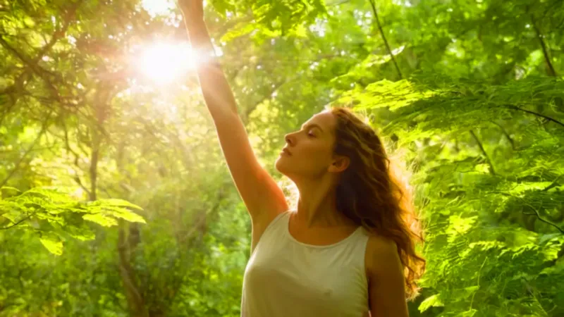 Mujer toca una hoja bajo la luz