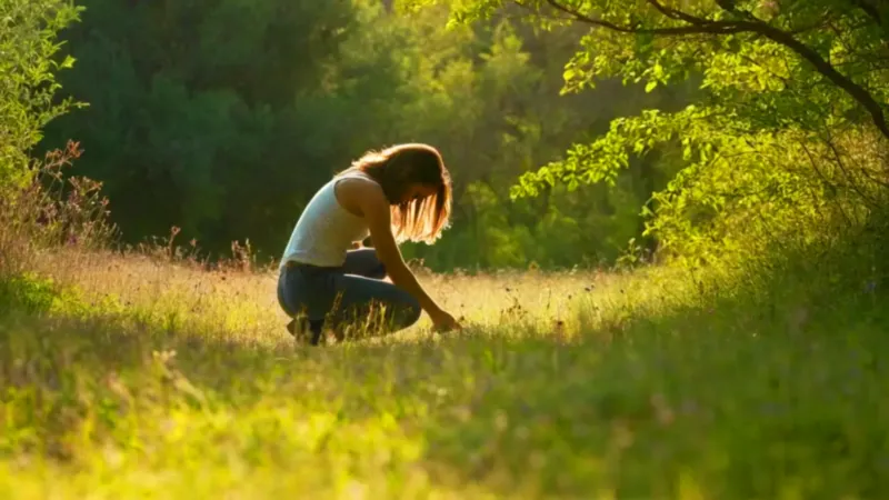 Figura arrodillada recogiendo bayas